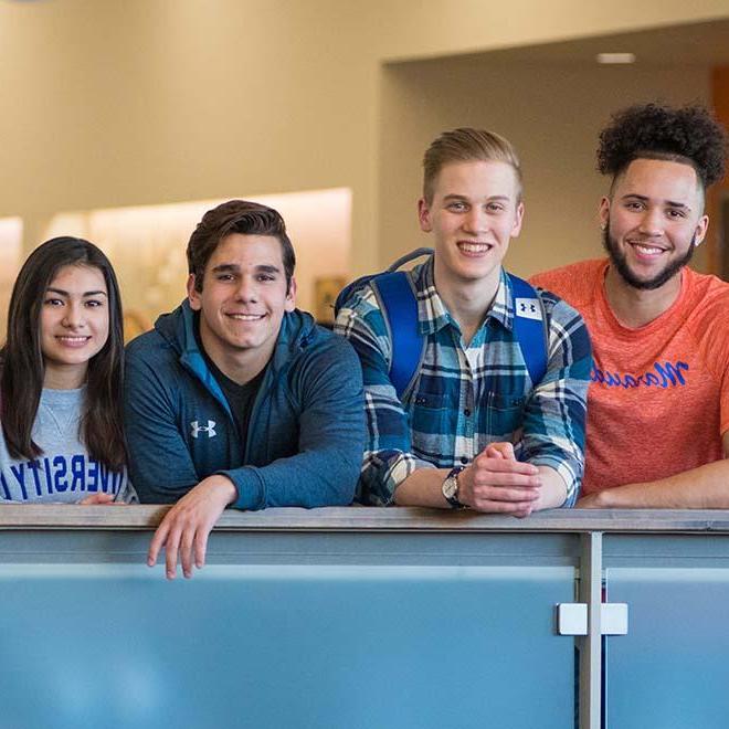 Four students smiling at the camera