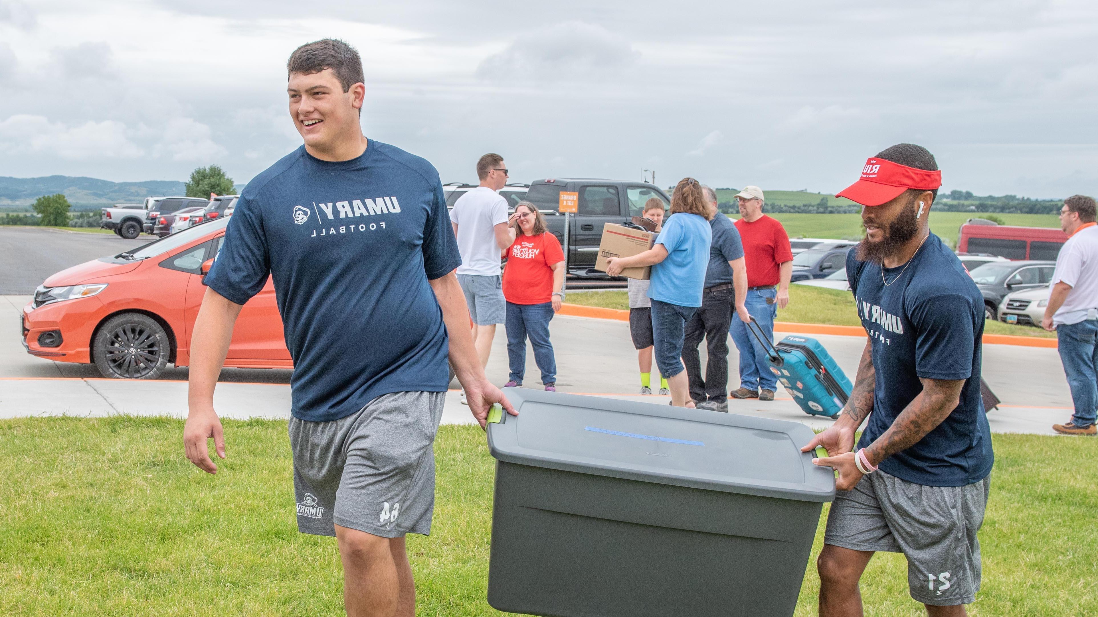 Two University of Mary football players helping during move in week.